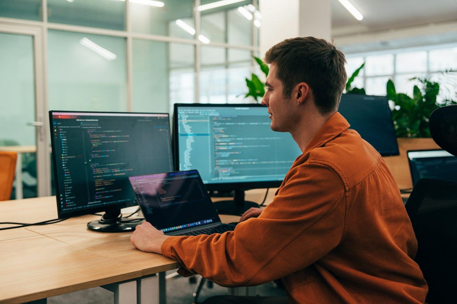 Engineer working across multiple monitors on a product platform
